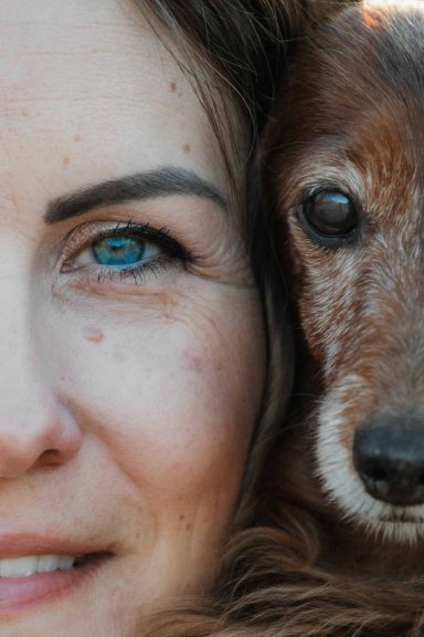 Frau mit einem Hund, der sich nahe an ihrem Gesicht befindet.